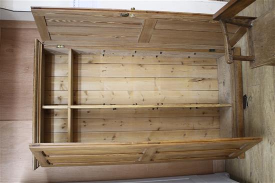 An Edwardian pitched pine hall cupboard, with two panelled doors enclosing two fixed shelves and fittings for adjustable shelves, W.116